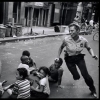 USA. New York City. 1978. A policewoman plays with local kids in Harlem.